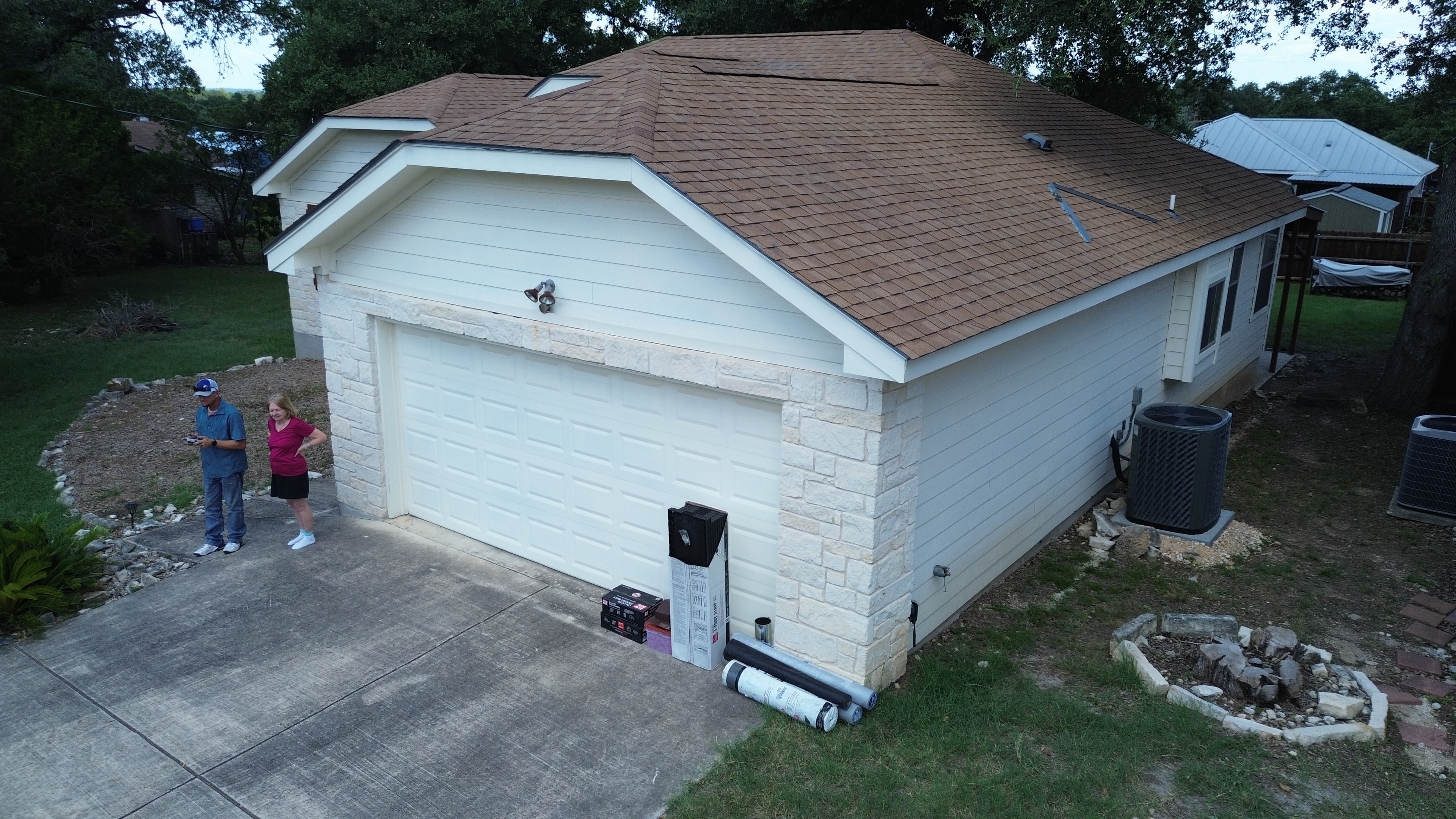 Residential garage with brown shingle roof