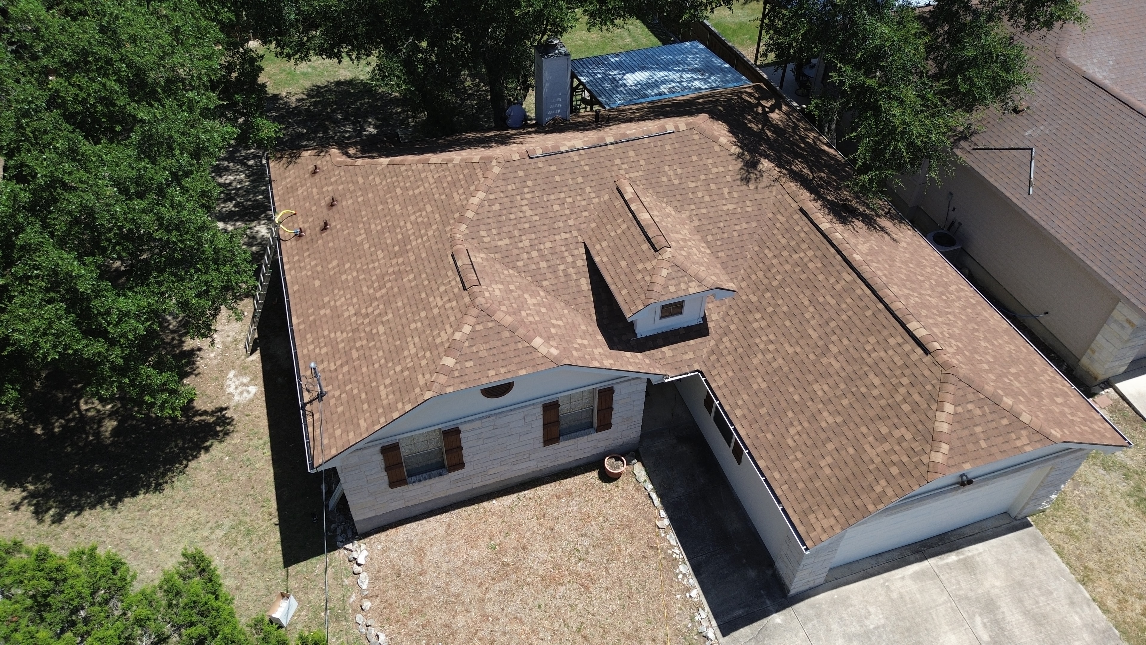 Aerial view completed brown shingle roof with dormer