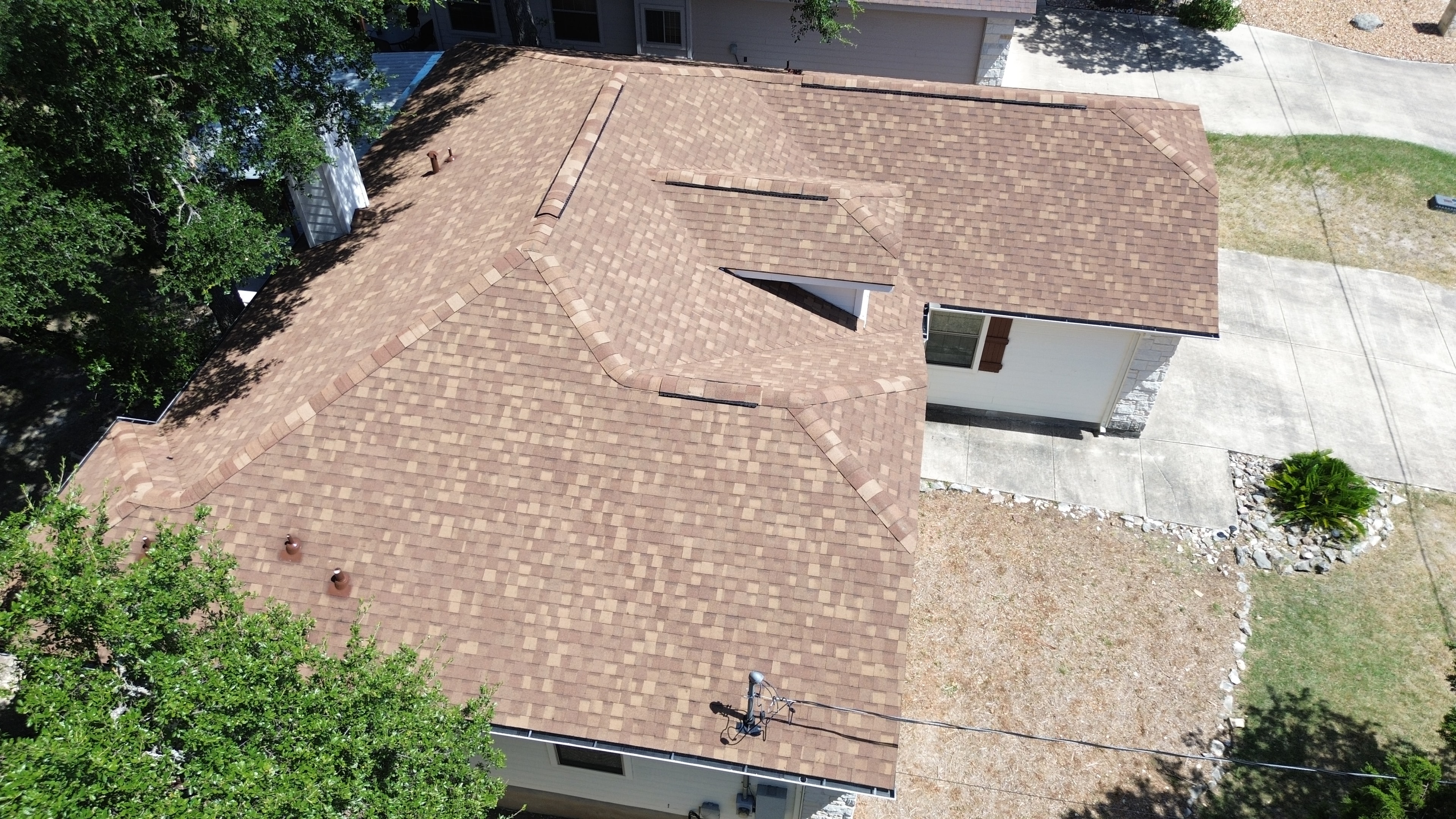 Aerial view completed brown shingle roof close-up